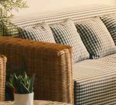 Close-up of the woven rattan arm and gingham cushions