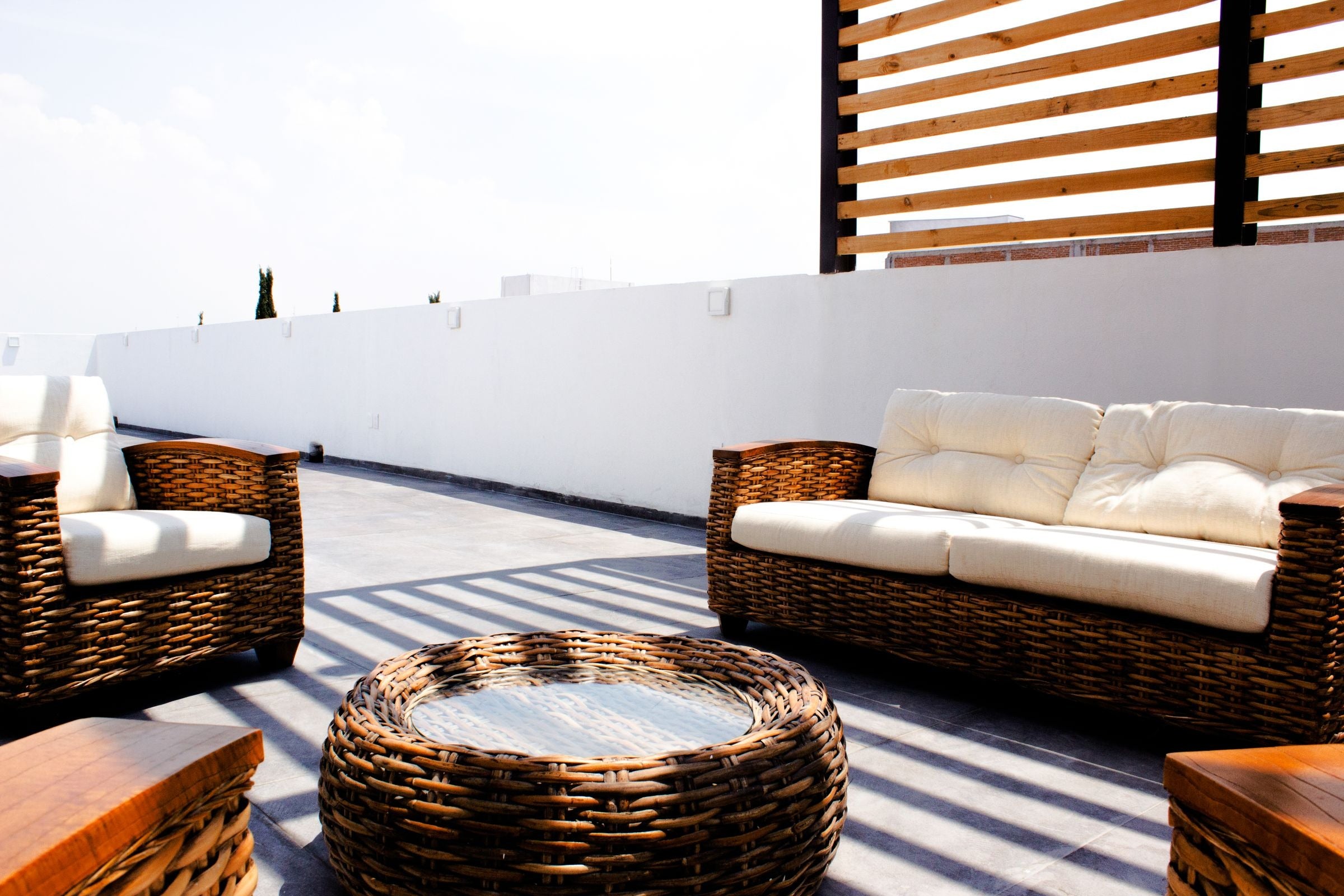 Terrace wicker sofa set with cream cushions on a rooftop
