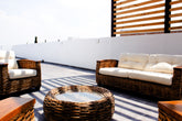 Terrace wicker sofa set with cream cushions on a rooftop