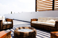 Terrace wicker sofa set with cream cushions on a rooftop