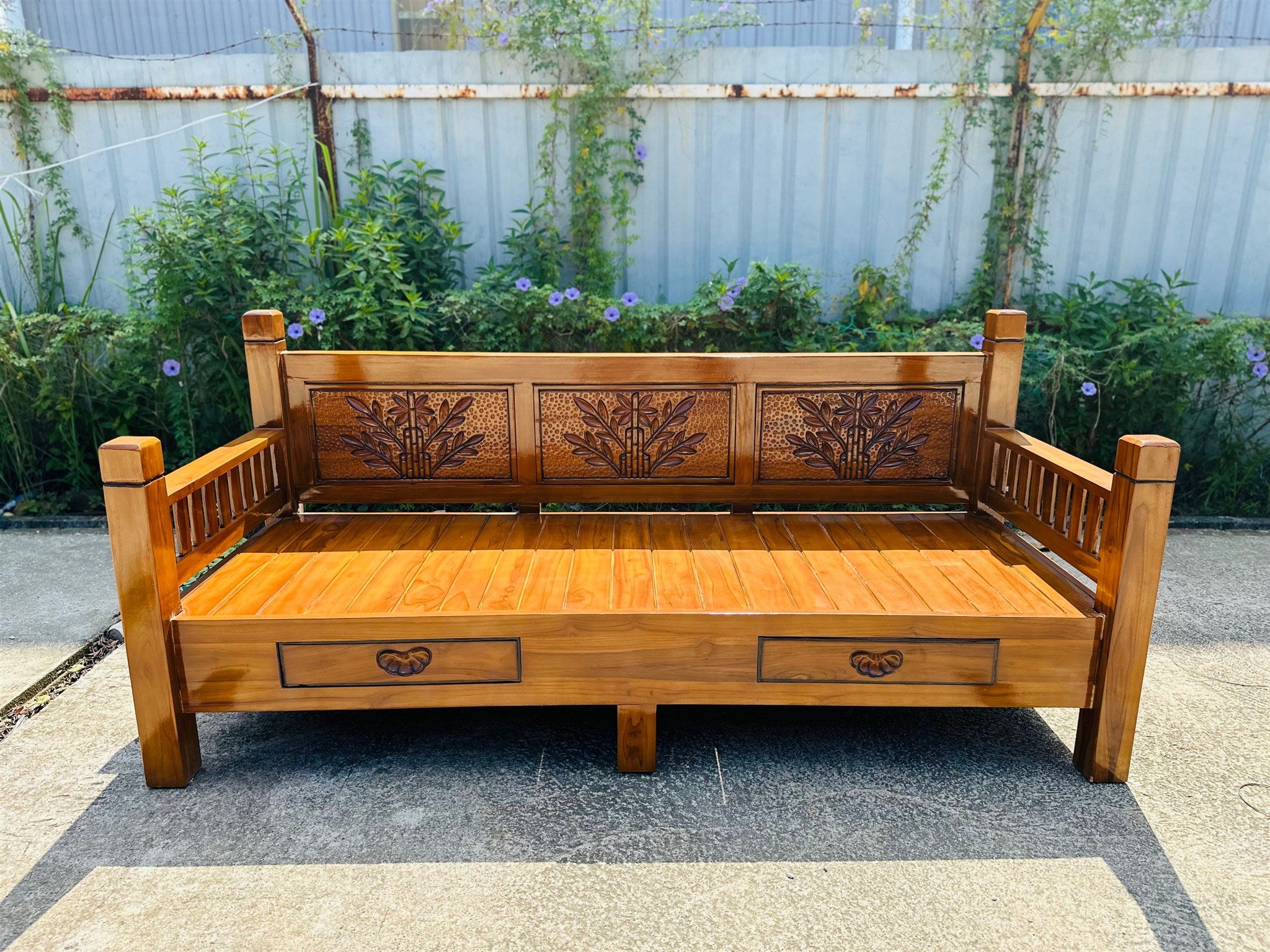 Shahi daybed frame showing hand-carved back panels and drawers